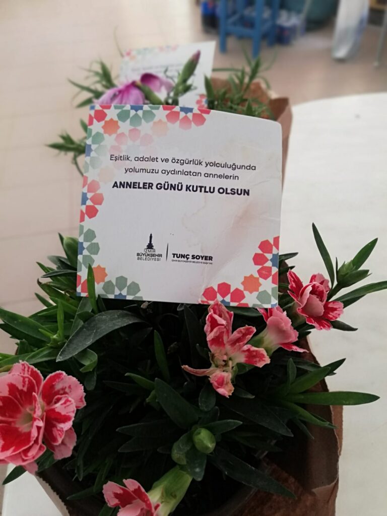 İzmir Büyükşehir, destek olmak için kooperatiflerden alınan 15 bin saksı karanfil ve dalya çiçeğini anneler ile kadın muhtarlara dağıtıyor.